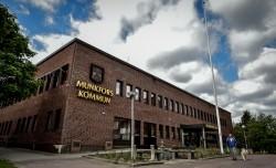 Kommunhusets framsida sett från marken och snett uppåt. På fasaden sitter en guldfärgad skylt med kommunvapnet och texten Munkfors kommun.