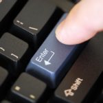 Finger som trycker på Enter-knappen