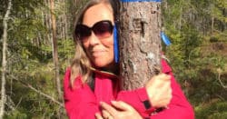 Birgitta kramar ett träd i skogen.