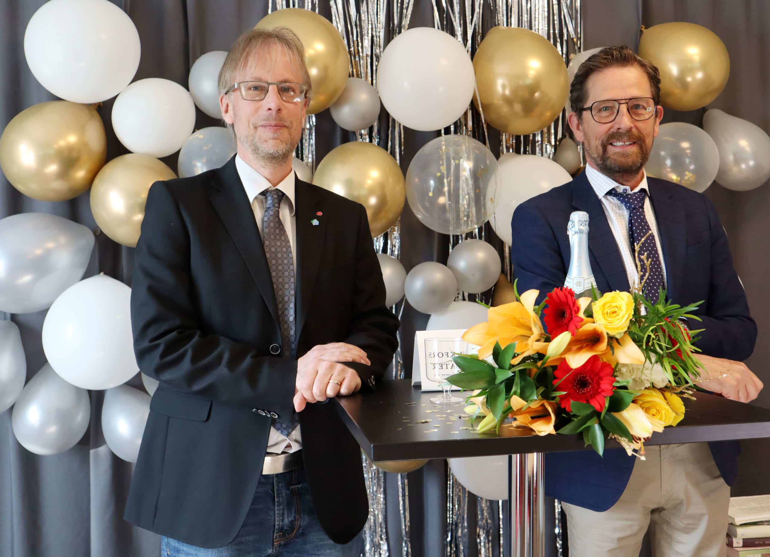 Mathias Lindquist, kommunalråd står tillsammans med kommunchef Jan-Olof Appel framför en vägg av ballonger.