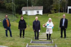 Kommunens representanter står tillsammans med hembygdsgårdens styrelse i amfiteatern.