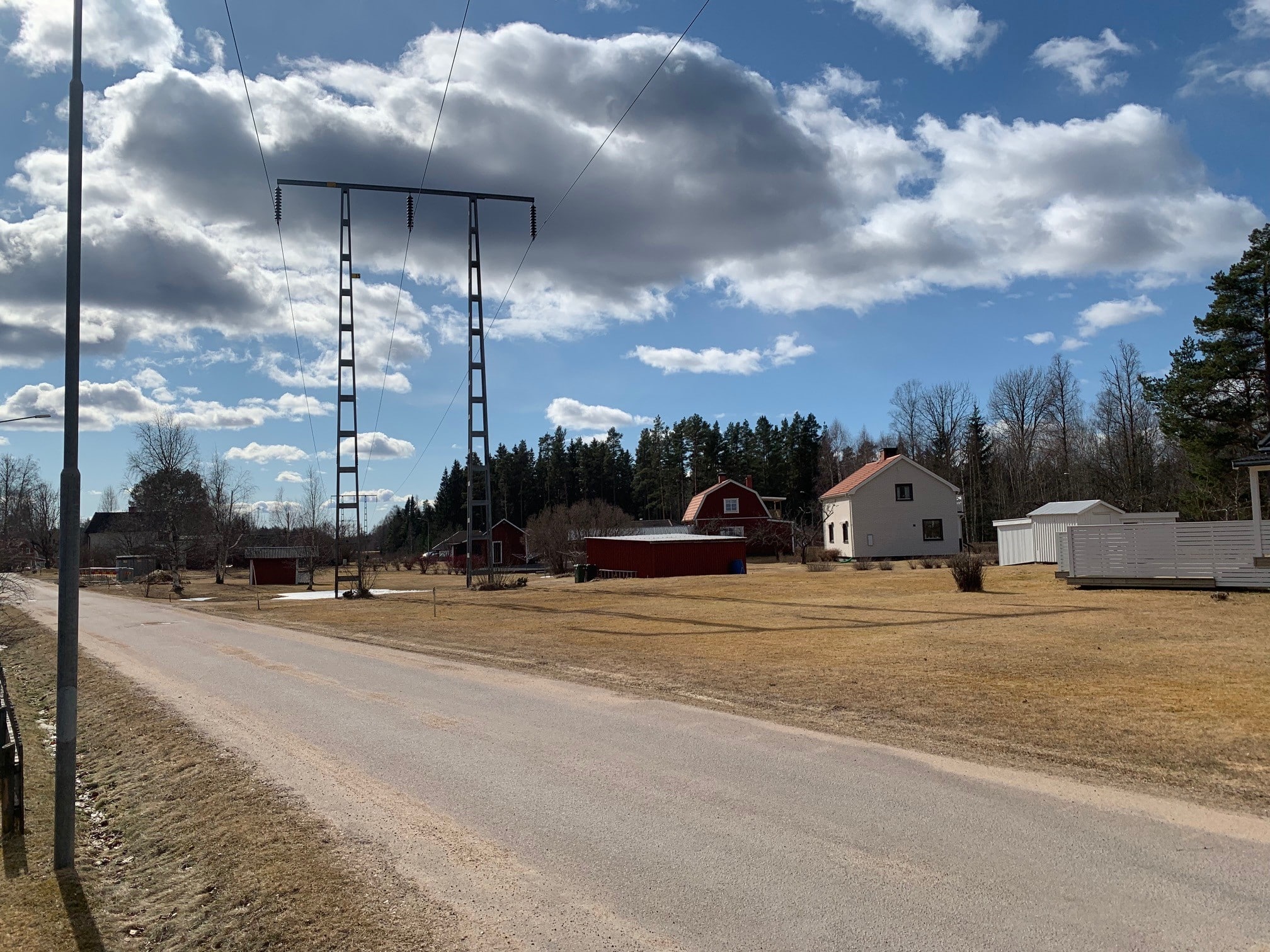 Ledningsstolpar intill bostadshus.