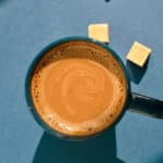 Kaffekopp med kaffe och två sockerbitar intill.