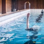 Person simmar ryggsim i en pool.