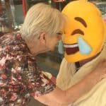 Dam håller om person med en Smiley-mask.