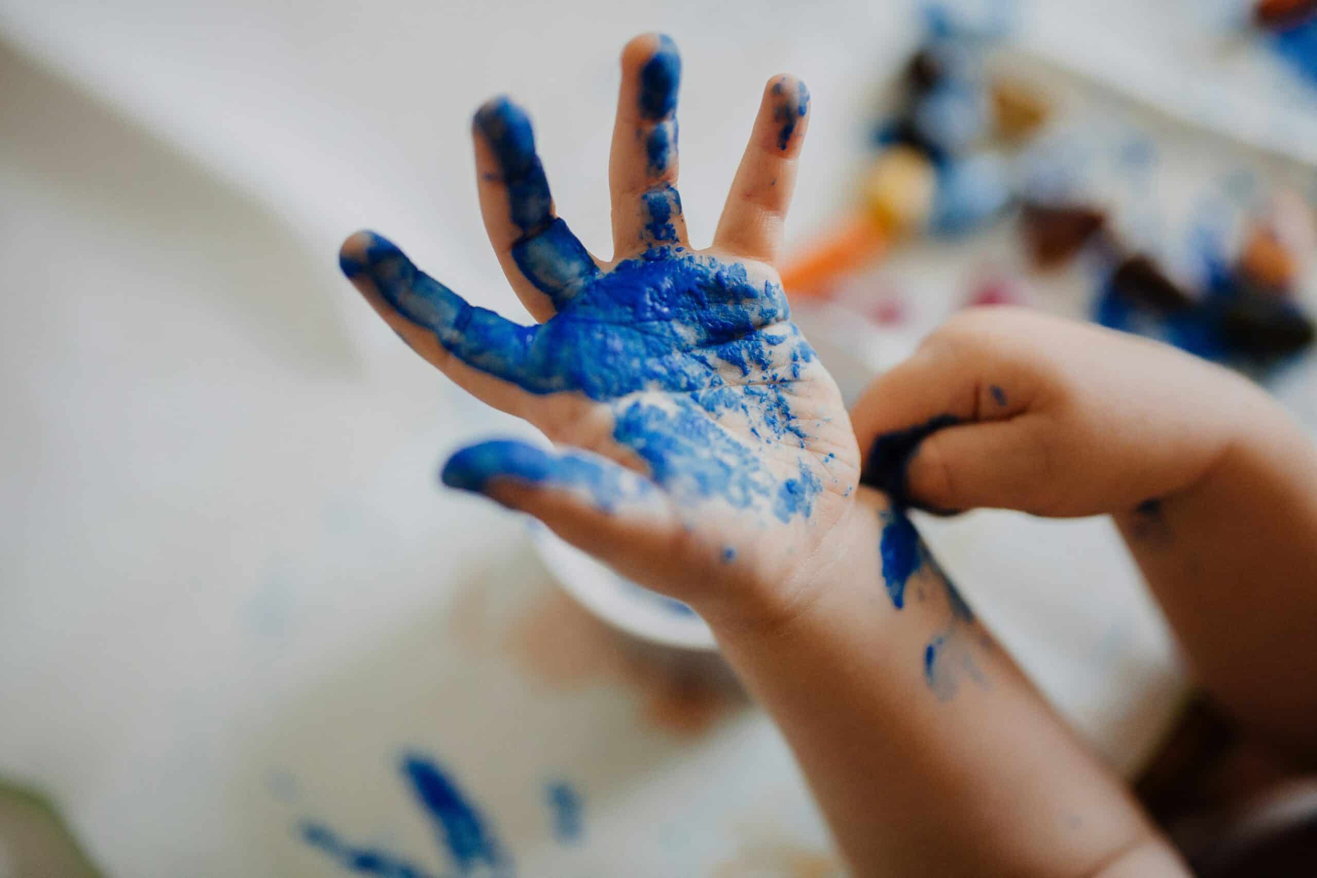 Barnhand med målarfärg.